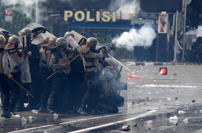 Bei einem Protest gegen das Omnibus-Gesetz der Regierung in Jakarta feuern Polizisten Tränengas auf die Demonstranten ab. Foto: epa/Adi Weda