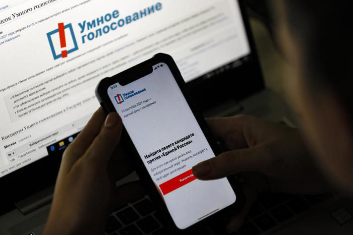 In Moskau prüft eine Frau Navalnys Smart-Voting-App auf ihrem Handy. Foto: epa/Sergei Ilnitsky