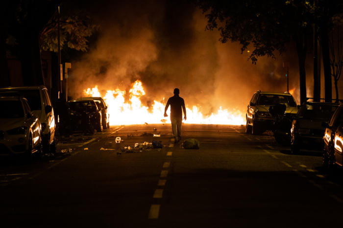 Ein Demonstrant geht während eines Protestes in Barcelona vor einer brennenden Barrikade. Foto: David Zorrakino/Europa Press/dpa 