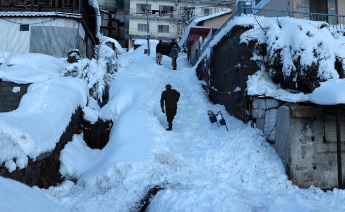 Menschen gehen auf einer schneebedeckten Straße in einem von starkem Schneefall betroffenen Gebiet in Murree. Foto: epa/Sohail Shahzad