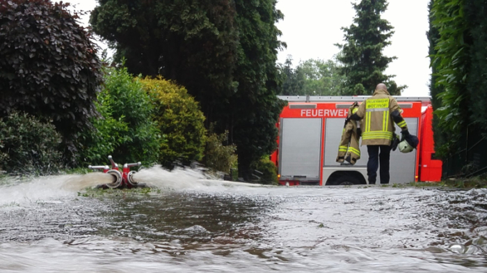 Nordrhein-Westfalen, Bottrop: Ein Feuerwehrmann geht über eine überflutete Straße. Starkregen und Gewitter haben in Teilen von Nordrhein-Westfalen zu zahlreichen wetterbedingten Einsätzen der Feuerwehr und Polizei... Foto: -/Feuerwehr Bottrop/dpa