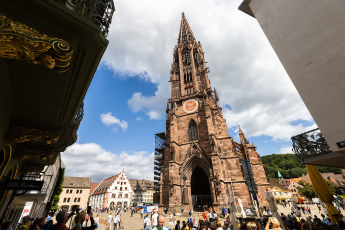 Menschen stehen auf dem Freiburger Münsterplatz vor dem Münster. Die Stadt im Südwesten des Landes erfreut sich sowohl bei Touristen wie auch bei Einheimischen großer Beliebtheit. Foto: Philipp Von Ditfurth
