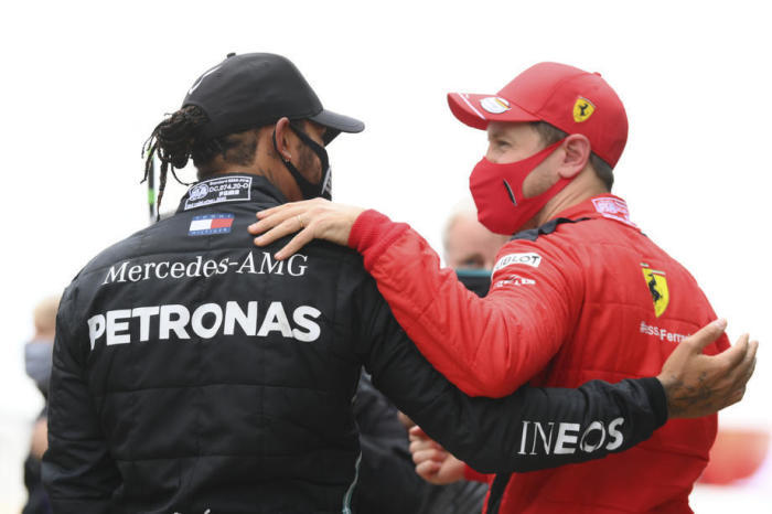 Der Drittplatzierte deutsche Formel-1-Pilot Sebastian Vettel von der Scuderia Ferrari (R) begrüßt den erstplatzierten britischen Formel-1-Piloten Lewis Hamilton. Foto: epa/Clive Mason