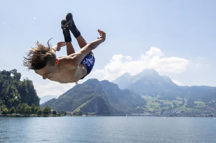 Jose springt im schweizerischen Stansstad in den Vierwaldstättersee. Foto: epa/Urs Flueeler