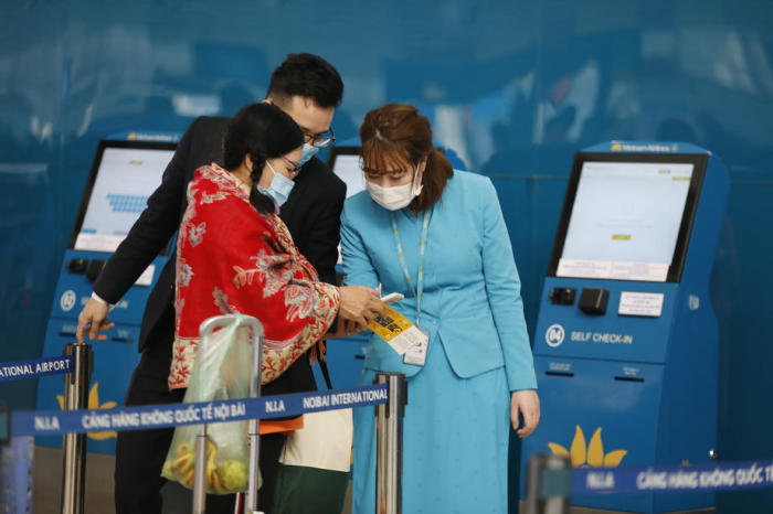Mitarbeiter von Vietnam Airlines helfen einem Kunden beim Online-Check-in am internationalen Flughafen Noi Bai in Hanoi. Foto: epa/Luong Thai Linh