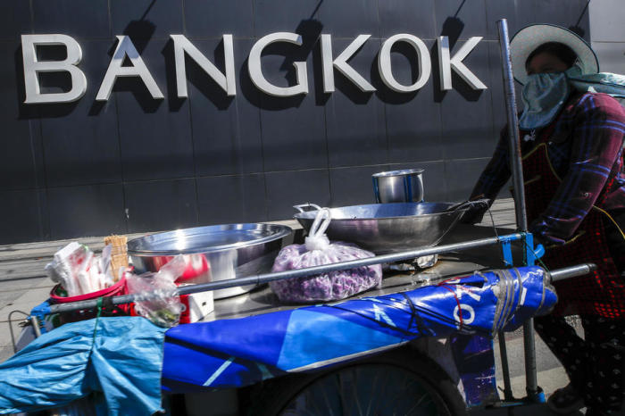 In Bangkok geht ein Lebensmittelverkäufer eine Straße entlang. Foto: epa/Diego Azubel