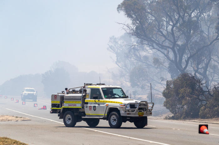 Einsatzfahrzeuge fahren durch Buschfeuerrauch auf der Patterson Road in Kwinana. Foto: epa/Richard Wainwright
