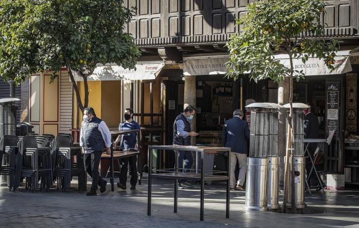 In Sevilla richteten Arbeiter die Terrasse in einer Bar ein. Foto: epa/Jose Manuel Vidal