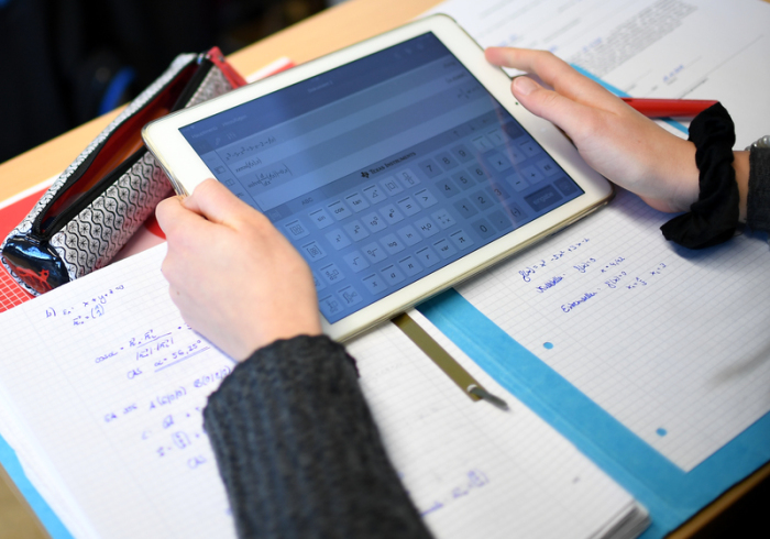 Ein Schüler des Gymnasium Carolinum errechnet eine Gleichung mit einem iPad im Matheunterricht. Foto: Britta Pedersen/Dpa-zentralbild/dpa