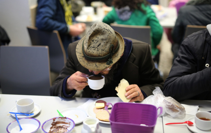 Ein Obdachloser frühstückt in der ökumenischen Wohnungsloseninitiative 