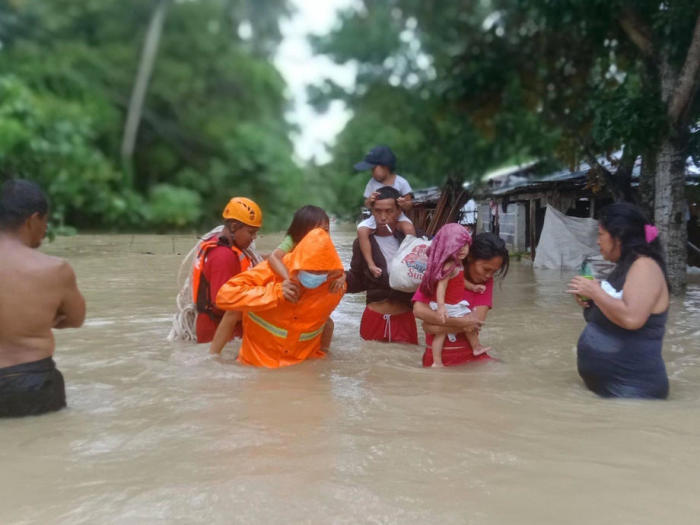 Das Management Office (QPDRRMO) zeigt Retter, die Kinder in der überfluteten Stadt Calauag in der Provinz Quezon tragen. Foto: epa/Qpdrrmo / Handout