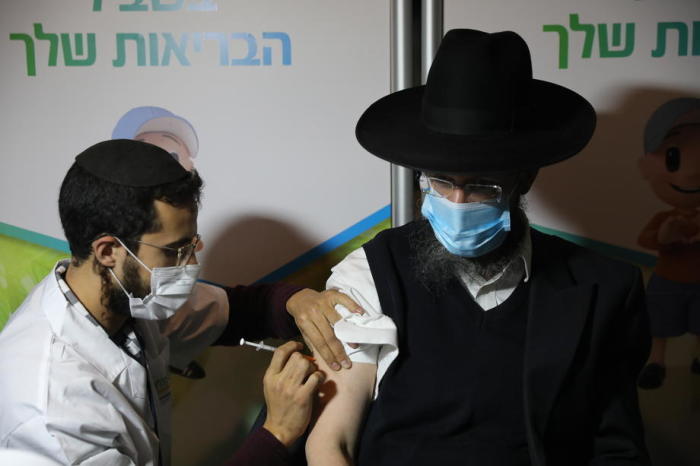 Ein ultra-orthodoxer jüdischer Mann wird in Jerusalem von einem Pfleger mit dem Pandemie-Impfstoff gegen das Coronavirus COVID-19 geimpft. Foto: epa/Abir Sultan