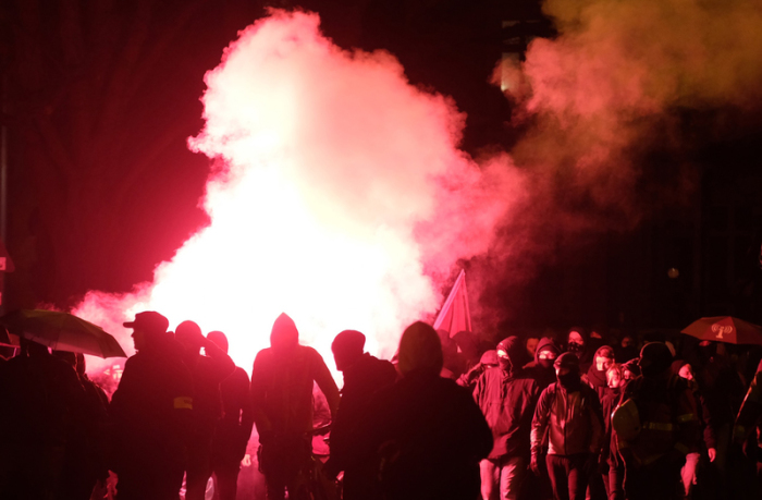 Teilnehmer einer linken Demonstration zünden Pyrotechnik.  Foto: Sebastian Willnow/Dpa-zentralbild/dpa