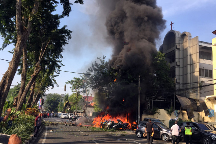 Ein von der Regierung von Surabaya zur Verfügung gestelltes Handout-Foto zeigt kurz nach einer Bombenexplosion in einer Kirche in Surabaya, Ost-Java, Indonesien, am 13. Mai 2018 ein brennendes Fahrzeug. Foto: epa/Surabaya Government/ANDY PINARIA