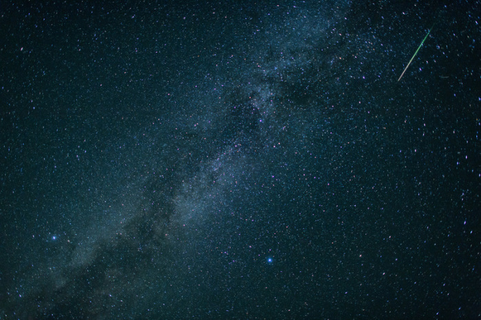 Eine Sternschnuppe leuchtet neben der Milchstraße am Himmel über dem Walchensee. Jedes Jahr im August sind im Sternschnuppenstrom der Perseiden zahlreiche Sternschnuppen zu sehen. Foto: Matthias Balk/Dpa