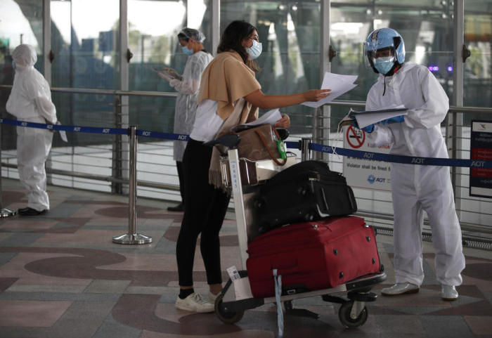 Eine Ausländerin wird am internationalen Flughafen Suvarnabhumi in Bangkok von medizinischem Personal empfangen. Foto: epa/Rungroj Yongrit