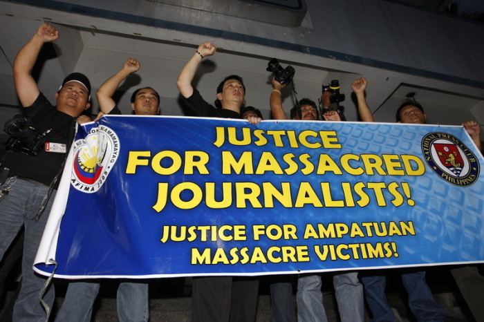 Philippinische Journalisten halten ein Transparent, während sie bei einer Protestdemonstration in einem Polizeipräsidium in Camp Crame in Quezon City, östlich von Manila, Parolen rufen. Foto: epa/Dennis M. Sabangan