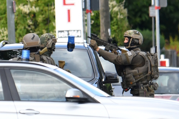 Einsatzkräfte des SEK stehen vor einem Gebäude. Ein Großaufgebot der Polizei hat ein Hotel im Münchner Vorort Aschheim nach einem bewaffneten Mann durchsucht. Foto: Tobias Hase/Dpa