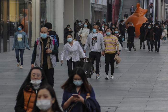 Die Leute gehen in einer Einkaufszone von Peking spazieren. Foto: epa/Wu Hong