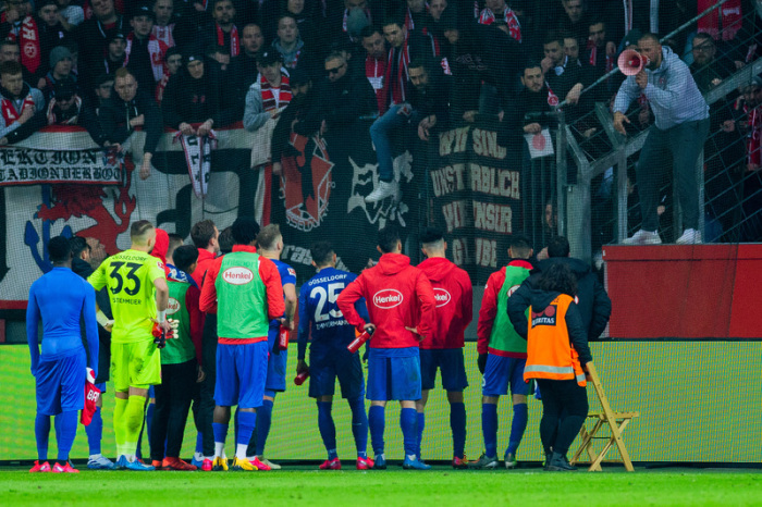 Die Düsseldorfer Mannschaft steht nach dem Spiel vor dem Gästeblock. Foto: Rolf Vennenbernd/Dpa
