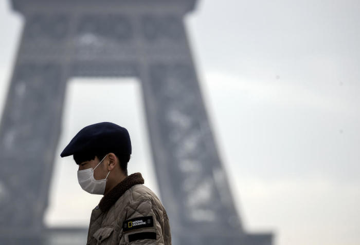 Ein Tourist trägt eine Gesichtsmaske beim Eiffelturm in Paris. Foto: epa/Ian Langsdon