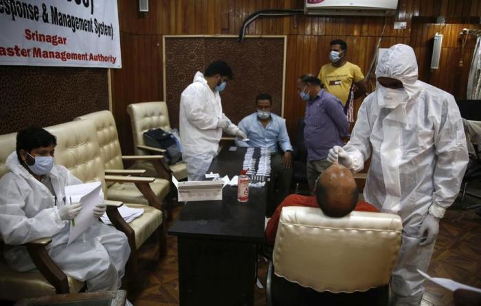 Ein Sanitäter entnimmt einem Regierungsangestellten einen Nasenabstrich, um einen Antigen-Schnelltest für Covid-19 in Srinagar durchzuführen. Foto: epa/Farooq Khan