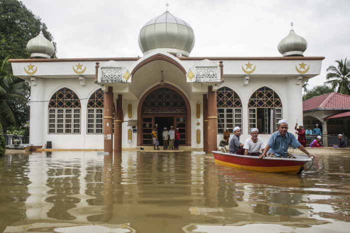 Muslimische Männer verlassen eine Moschee nach dem Freitagsgebet während der Überschwemmungszeit im Bezirk Tumpat, nahe der Grenze zu Thailand, Kelantan. Foto: epa/Fazry Ismail