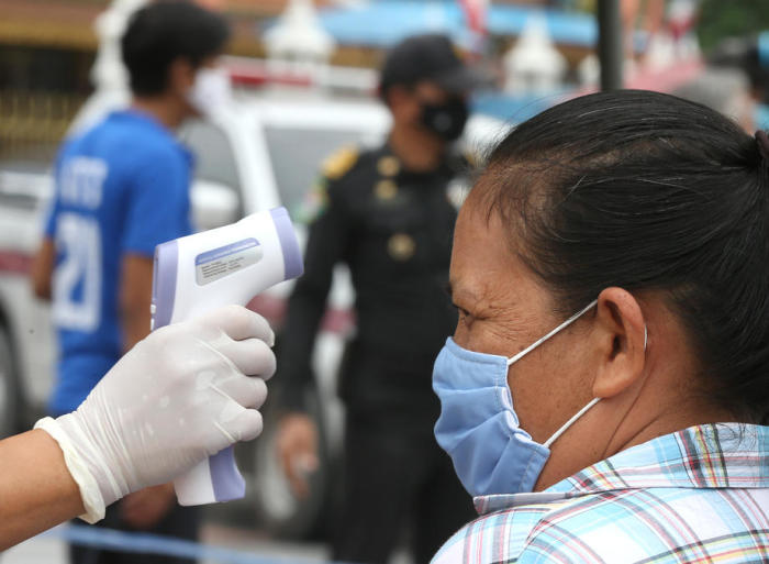 Temperatur-Screening bei einer Unterstützungsaktion für Notleidende in Bangkok. Foto: epa/Narong Sangnak