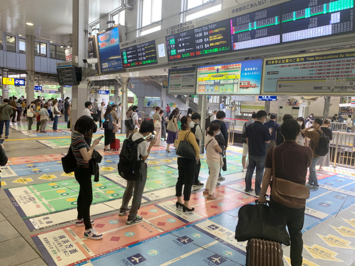 Reisende stehen auf zahlreichen Markierungen im Bahnhof Shinagawa. Japaner werden auf Schritt und Tritt zu korrektem Benehmen aufgefordert. Eine schier unüberschaubare Flut an Verhaltensregeln begleitet ihren Alltag. ... Foto: Lars Nicolaysen/dpa