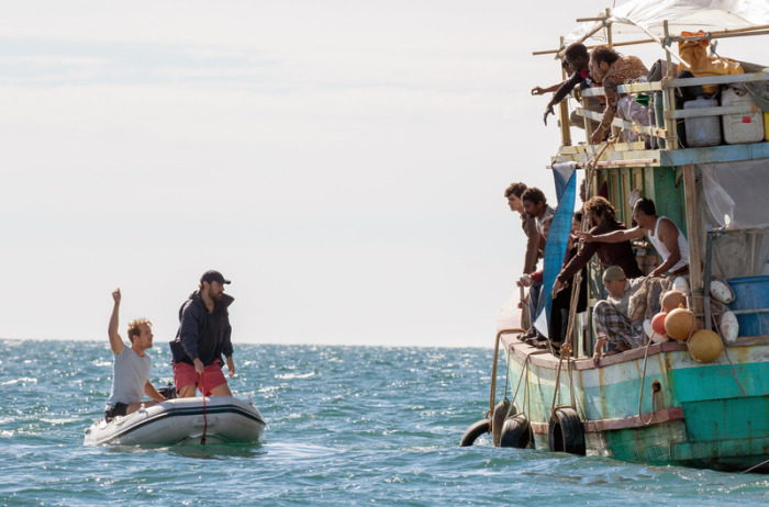 Ryan (Ewen Leslie, r im Boot) und Damien (Joel Jackson, l im Boot) wollen den Flüchtlingen helfen - eine Szene aus der ersten Folge der Serie 