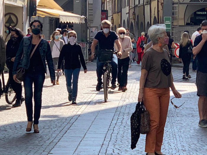 In Bozen gehen Menschen mit Gesichtsmasken auf einer Straße. Foto: epa/G. Nachrichten