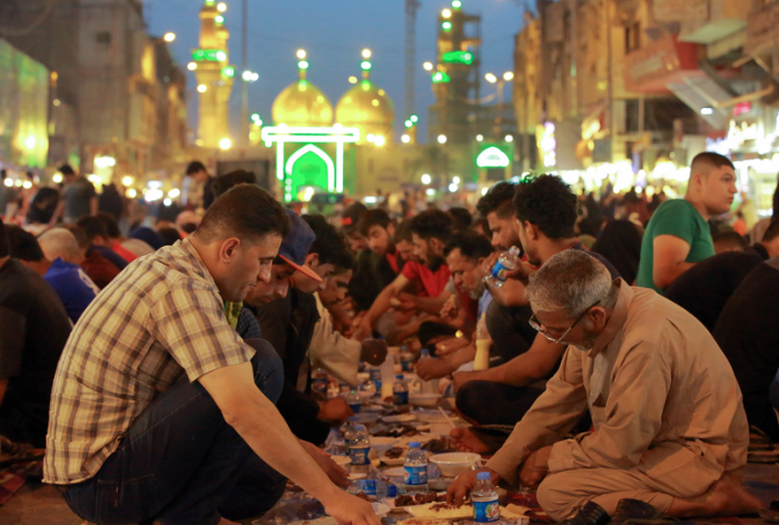 Muslime haben sich unter freiem Himmel zu einem kostenlosen öffentlichen Abendmahl (Iftar) während des muslimischen Fastenmonats Ramadan in Bagdad (Irak) versammelt. Foto: Ameer Al Mohammedaw/dpa