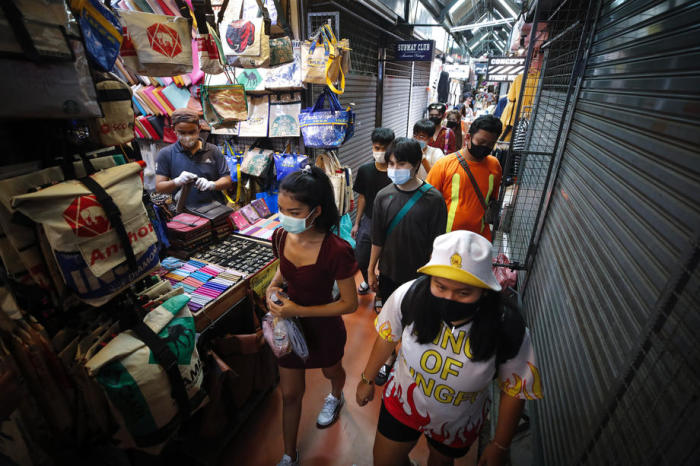 Menschen mit Schutzmasken betreten den Chatuchak-Wochenendmarkt in Bangkok. Foto: epa/Diego Azubel