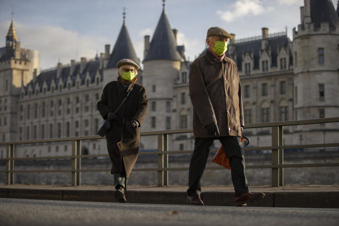 Spaziergänger mit Gesichtsschutzmasken gehen am Ufer der Seine in Paris entlang. Foto: epa/Ian Langsdon