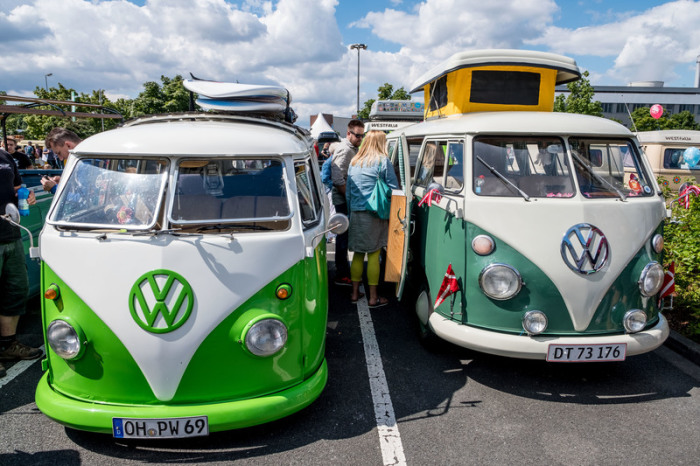 Besucher betrachten die alten VW-Bullis während des Bulli-Treffens zum 70-jährigen Jubiläum des Volkswagen-Transporter auf dem Gelände der Volkswagen-Nutzfahrzeuge Werk Stöcken. Foto: Peter Steffen/Dpa