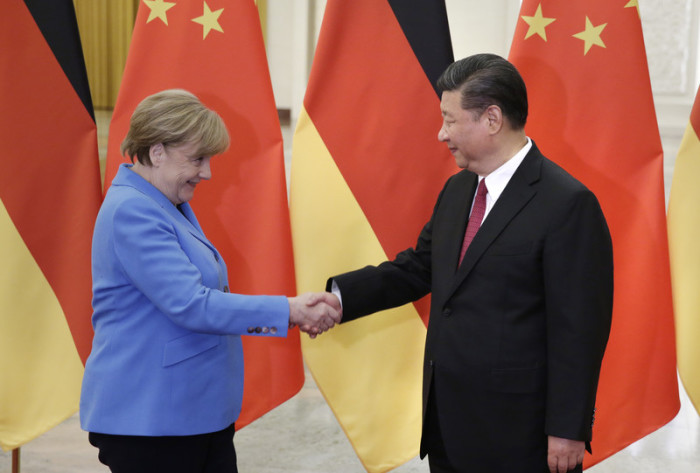 Chinas Präsident Xi Jinping (r.) schüttelt der deutschen Bundeskanzlerin Angela Merkel (l.) die Hand. Foto: epa/Jason Lee