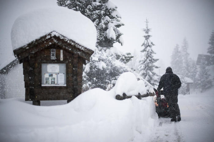 In Valens räumt ein Mann mit einer Schneefräse einen Fußweg bei starkem Schneefall. Archivfoto: epa/GIAN EHRENZELLER