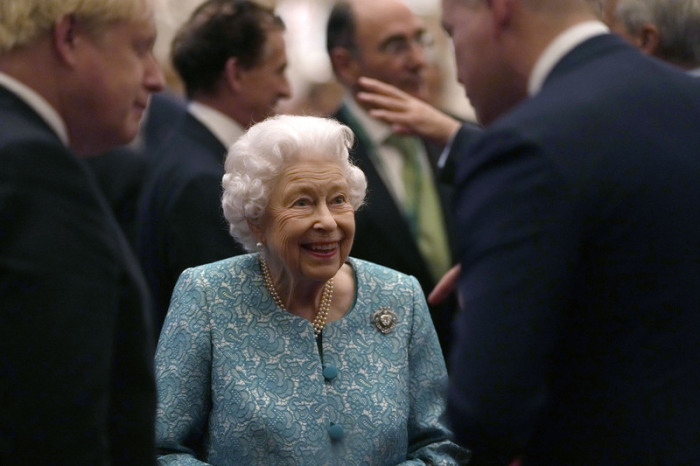 Königin Elizabeth II. (M) lächelt, als sie zusammen mit Boris Johnson (l), Premierminister von Großbritannien, Gäste zu einer Veranstaltung im Rahmen des Globalen Investment-Gipfels auf Schloss Windsor begrüßt. Foto: Alastair Grant