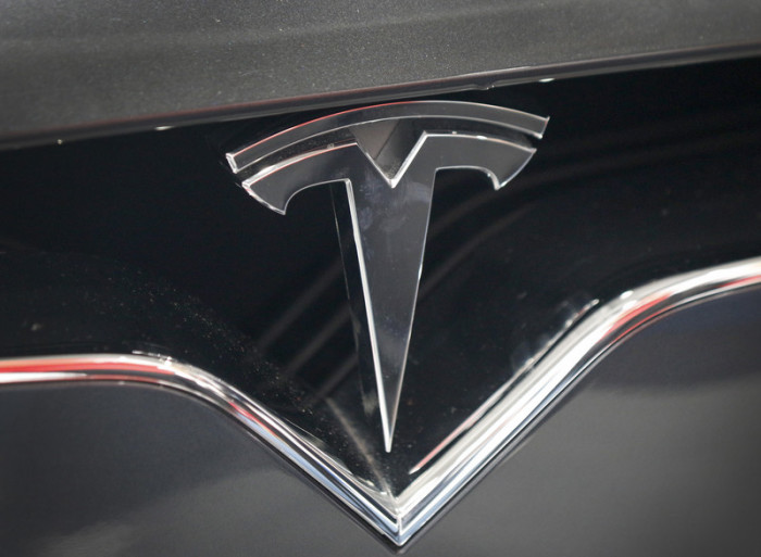 Ein Logo des Elektroautoherstellers Tesla. Foto: epa/Focke Strangmann