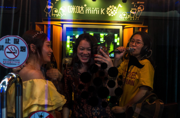 Drei Frauen amüsieren sich in einer chinesischen Karaoke-Bar. Archivbild: epa/Aleksandar Plavevski