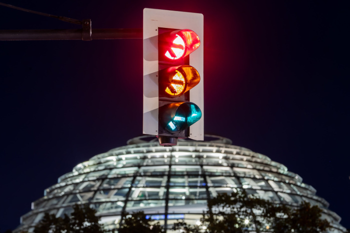 Eine Ampel vor der Kuppel des Reichstagsgebäudes leuchtet in einer Langzeitbelichtung in allen drei Phasen. Der Parteivorstand der SPD hat der Aufnahme von Koalitionsgesprächen mit Grünen und FDP zugestimmt. Foto: Christoph Soeder/dpa