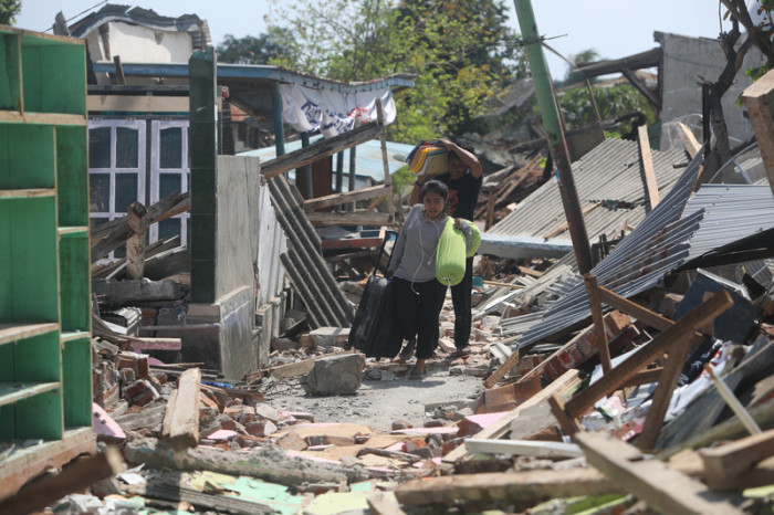 Einwohner des Ortes Bangsal im Norden von Lombok retten ihr Hab und Gut aus den Trümmern. Foto: epa/Adi Weda