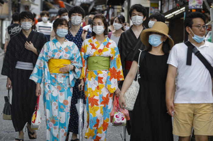 In Kimono bekleidete Frauen mit schützenden Gesichtsmasken gehen in der Nähe des Kiyomizudera-Tempels in Kyoto. Foto: epa/Dai Kurokawa