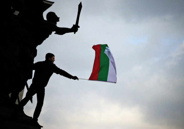 Ein Student weht eine Nationalflagge vor dem bulgarischen Parlament bei einem Protest in Sofia. Foto: epa/Vassil Donev