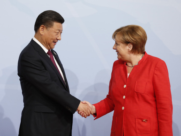 Xi Jinping, Staatspräsident der Volksrepublik China, begrüßt Bundeskanzlerin Angela Merkel. Foto: Soeren Stache/Dpa