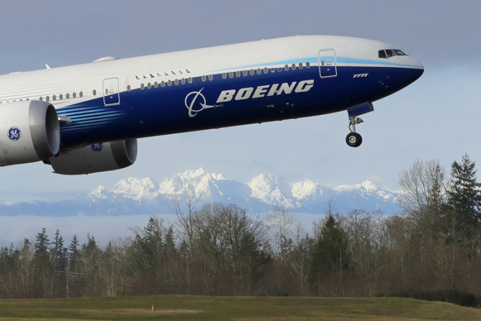 Ein Flugzeug vom Typ Boeing 777X startet zu seinem ersten Flug mit den «Olympic Mountains» im Hintergrund in Paine Field. Boeing gibt am 27.10.2021 Zahlen für das 3. Quartal bekannt. Foto: Ted S. Warren/Ap/dpa
