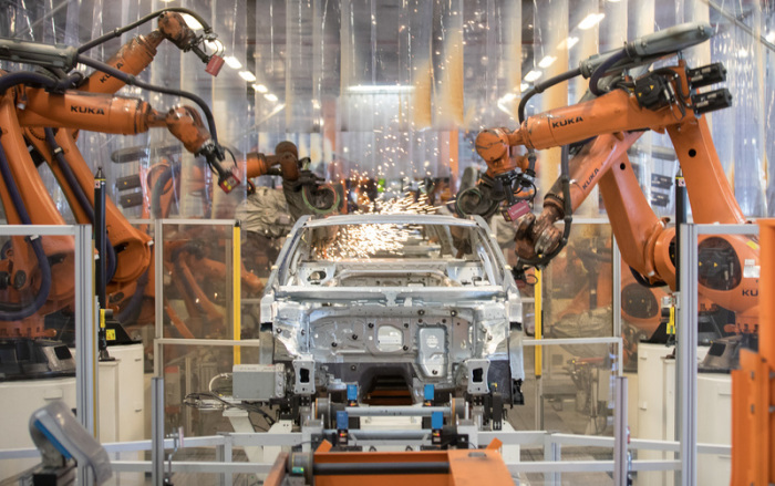 Teile eines VW Passat werden im Karosseriewerk von VW von Robotern zusammengefügt. Foto: Jörg Sarbach/Dpa