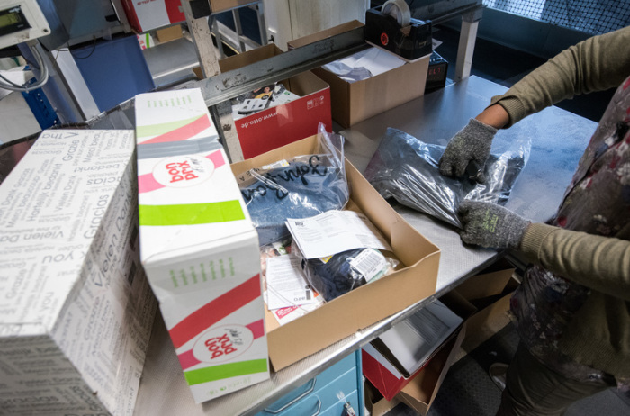 Eine Mitarbeiterin kontrolliert im Rücksendezentrum Pakete mit Retouren. Die Deutschen bestellen immer mehr im Internet. Foto: Daniel Bockwoldt/Dpa