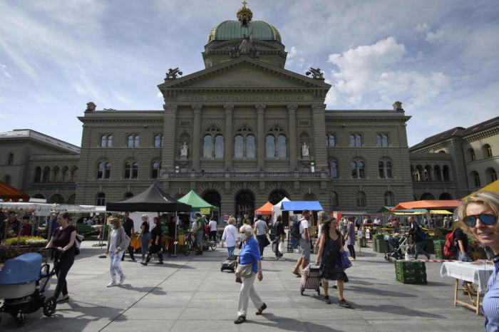 Die Kundschaft besucht den wöchentlichen Lebensmittelmarkt vor dem Schweizer Parlamentsgebäude, dem Bundeshaus in Bern. Foto: epa/Anthony Anhang