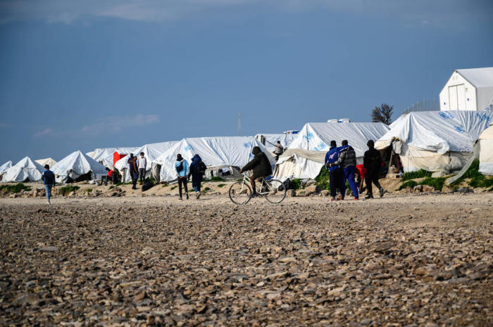 Einwanderer gehen vor ihren Zelten im Flüchtlingslager Karatepe auf der Insel Lesbos spazieren. Foto: epa/Vangelis Papantonis